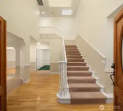 Double door entryway with grand staircase to second level.