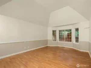 Main floor primary bedroom with vaulted ceilings and forest view.