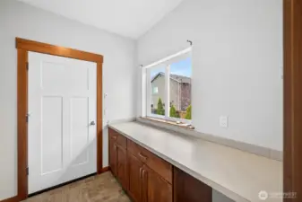 Oversized utility room just off the garage with desk and storage space.