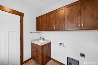 Utility room sink and storage cabinets.
