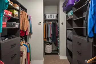 The expansive walk-in closet features built-in shelving and drawers for ultimate organization and convenience.