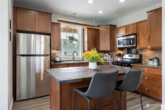 The chef in you will appreciate the well-appointed kitchen featuring high-end appliances, granite countertops, and plenty of storage. An island with a breakfast bar provides additional seating and workspace.