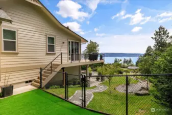 Slider from primary bedroom sitting room opens to the side deck. Viewed from fenced pet area.