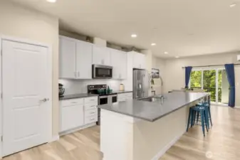 Oversized kitchen island comfortably seats 6. Roomy walk-in pantry to the left.