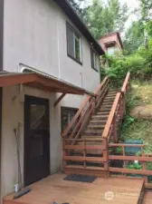 Lower entry, on deck with staircase to parking area and garage