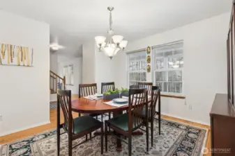 A view of the dining space from the kitchen shows the entry, and hallway passage to the front door, living room, upper and lower levels.