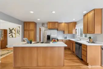 Looking over the convenient kitchen island from the great room seating area you can see the large pantry cupboard, utility/mudroom with large pantry closet, and access to back covered porch, garage and half bath.