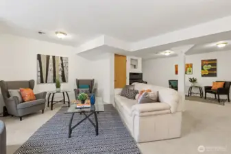 Looking toward the rear of the huge basement living space you see the door to a very large under stair storage closet, the passage to the stairs to the upper level, and beside that, the den/bonus room off this open space.