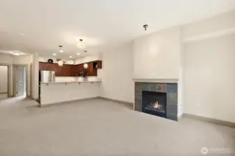 Another angle of the Dining and Living room with gas fireplace and the Kitchen beyond.