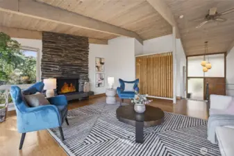 Vaulted open-beamed ceiling throughout the entire main floor.  Dramatic stacked rock floor-to-ceiling fireplace with stone tiled hearth. Notice the open-pole bamboo divider wall accent to define the hallway.