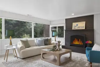 Wall of windows in the main living area and floor-to-ceiling brick fireplace.