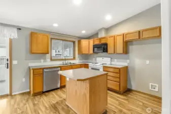 This home comes with the three appliances: dishwasher, stove/range, and microwave!  The window looks out at the backyard.