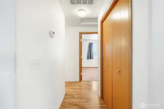 Here we are going down the hall off the front entrance to check out the bedrooms and this large pantry closet with shelving, to the right.