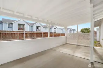 This covered back patio is one of our favorite things about this home. It has fresh paint and brand new lattice to protect you from the sun and wind, and adds a little bit of extra privacy for you.