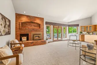 Large family room, overlooking rear deck via French doors, is oversized, with 1 of 3 fireplaces in the home, this a wood-burning insert.