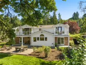 Welcome to this beautifully remodeled home, where timeless design blends seamlessly with modern comforts and a lush green backdrop.