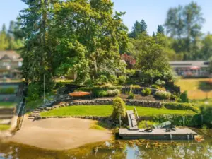 The open lawn is framed by evergreens, offering space for play, gardens, or outdoor entertaining. It’s a natural extension of the home’s indoor living.