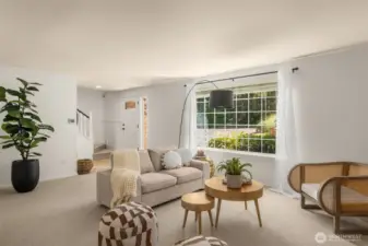 An inviting living room with picture windows allows sunlight to pour in and highlight the spacious interiors.