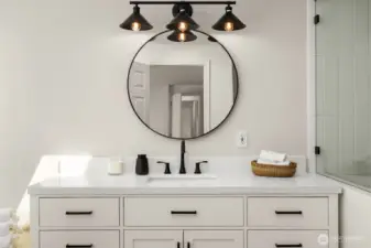 The spa-like bathroom features double vanities, chic lighting, and elegant finishes. Every detail is designed to elevate daily routines into moments of luxury.