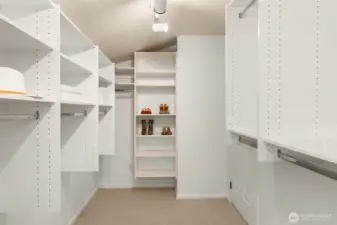 Look at this walk-in closet! Expansive and thoughtfully organized, it offers custom shelving that ensures a place for everything while keeping storage stylish and functional.