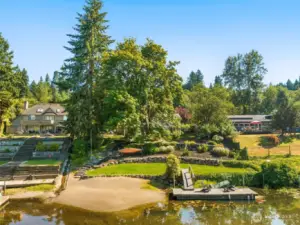 The open lawn is framed by evergreens, offering space for play, gardens, or outdoor entertaining. It’s a natural extension of the home’s indoor living.