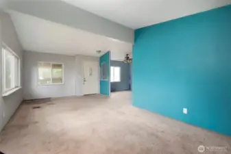 Front door into living room with vaulted ceiling.