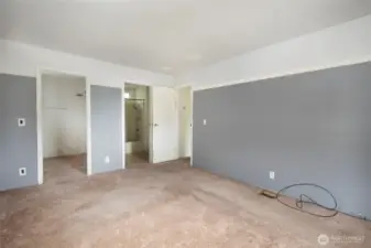Primary bedroom with doors into walk in closet and ensuite bathroom.