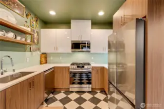 Step into a bright, impeccably clean kitchen featuring sleek stainless steel appliances, generous counter space, and abundant storage. A cleverly designed pantry under the stairs adds both function and charm