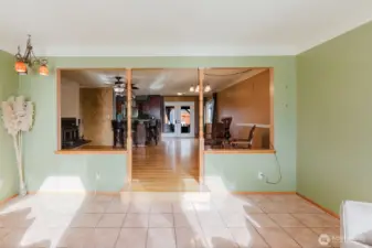 Sunroom open to the main living area with step-up transition to hardwood floors.