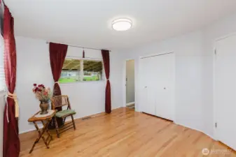 Spacious primary bedroom with hardwood floors and window offering natural light and partial mountain views.