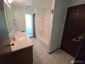 Spacious bathroom with door leading to the primary