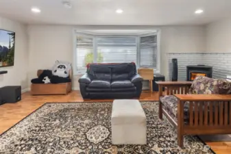 Bonus room features recessed lighting, large bay window, and pellet fireplace.