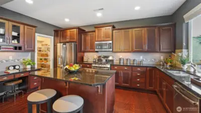 The kitchen is large and very well appointed.  The counters and island are granite with tile back splash.