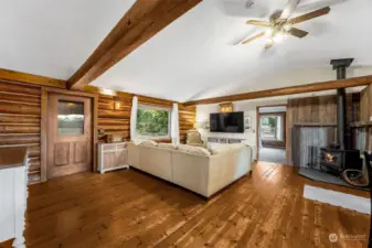 Warm & open log cabin -experience the natural beauty of hardwood floors and exposed beams, complemented by a classic wood stove for the perfect rustic escape.