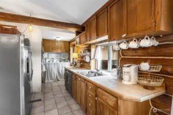 The heart of this home is its beautifully designed kitchen, complete with warm wood tones, natural light, and inviting details that blend perfectly with the hardwood floors and exposed beams.