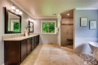 Organic and elegant Primary bathroom with travertine floors and expresso cabinets.