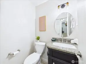 A powder room is conveniently located on the main floor for your guests to use. Nice dark vanity with granite countertop.