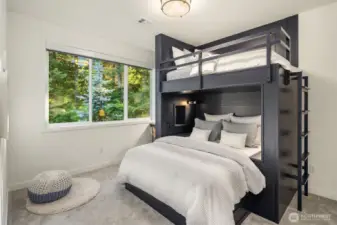 A unique bedroom offering custom-built bunk beds, queen on bottom and twin on top, as well as an integrated desk—perfect for work and play