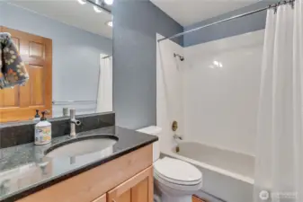 The second full bathroom has granite counters and custom cabinetry.