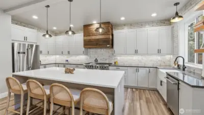 Don't miss the rustic, custom hood over the commercial grade stove!