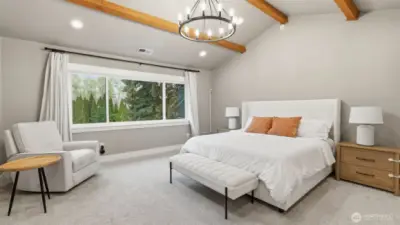 Exposed beams and a large window with a view of the private backyard.