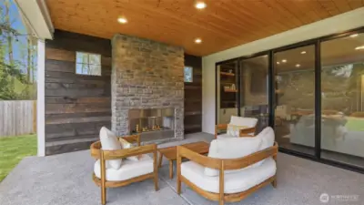 Covered outdoor living space with gas fireplace and exposed wood wall!
