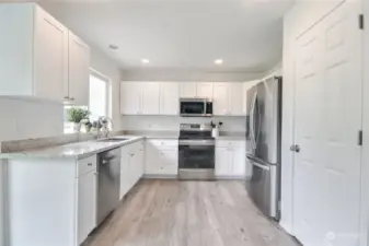 Beautifully updated kitchen with new white cabinets, stainless steel appliances, Quartz counters, LVP flooring, large pantry closet, under mount sink & more