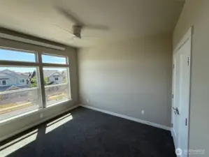 Bedroom 1 is bright and airy with a ceiling fan