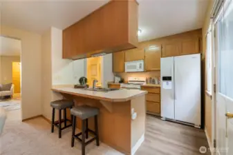 The kitchen has an eat-in counter and appliances that stay!