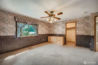 More of the primary bedroom with walk in closet straight ahead and a primary bath to the right.