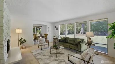 Relax in this sun-filled living room framed by walls of windows overlooking the lush backyard.