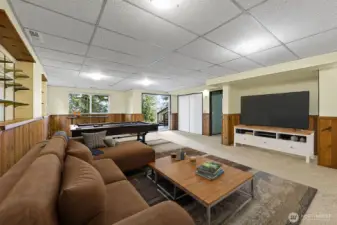 Heading downstairs you will come into a large bonus room area with slider doors out to the back patio and stairs that go up to the top deck. Oh so many uses for the space  in this room-virtually staged