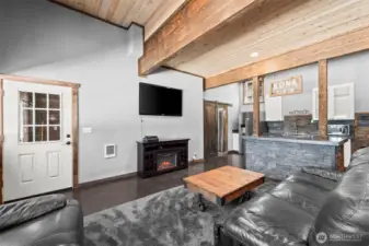 Open concept living room with vaulted ceilings, pellet stove, and natural light throughout.