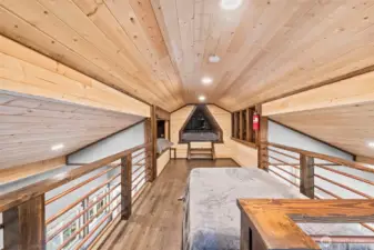 Loft space overlooking main living area with vaulted ceilings and natural light.